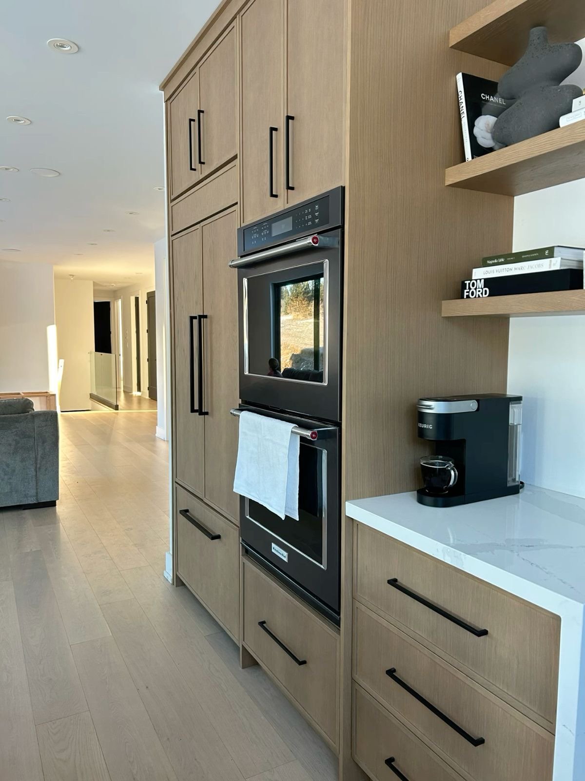 Contemporary U-shaped kitchen with marble backsplash and black hood